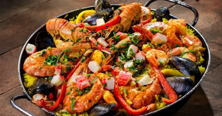 A vibrant pan of authentic Spanish paella filled with golden saffron rice, fresh seafood, and colorful vegetables.